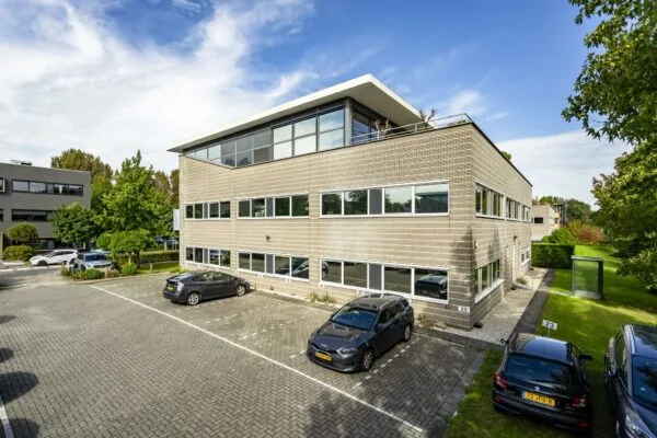 Modern kantoorgebouw aan de Jan Leentvaarlaan met parkeerplaatsen en groenvoorziening.